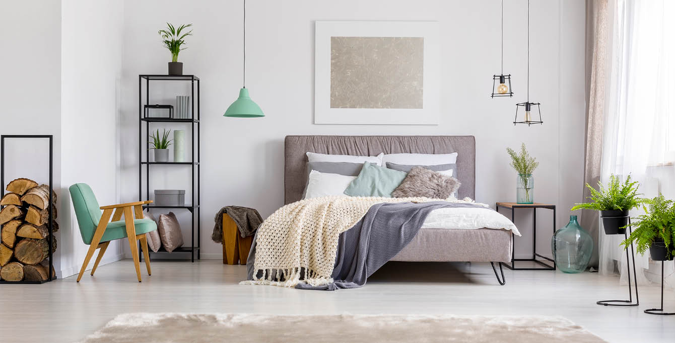 Modern bedroom interior with grey, king-size bed, metal shelf and fur carpet